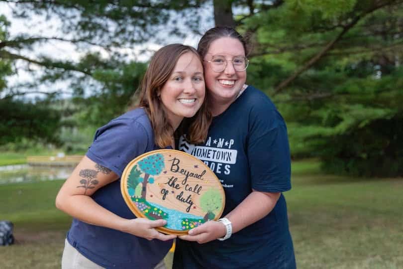 Two women holding a sign.